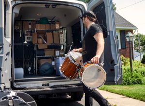 photo of a man loading drums while on tour on a shoestring budget