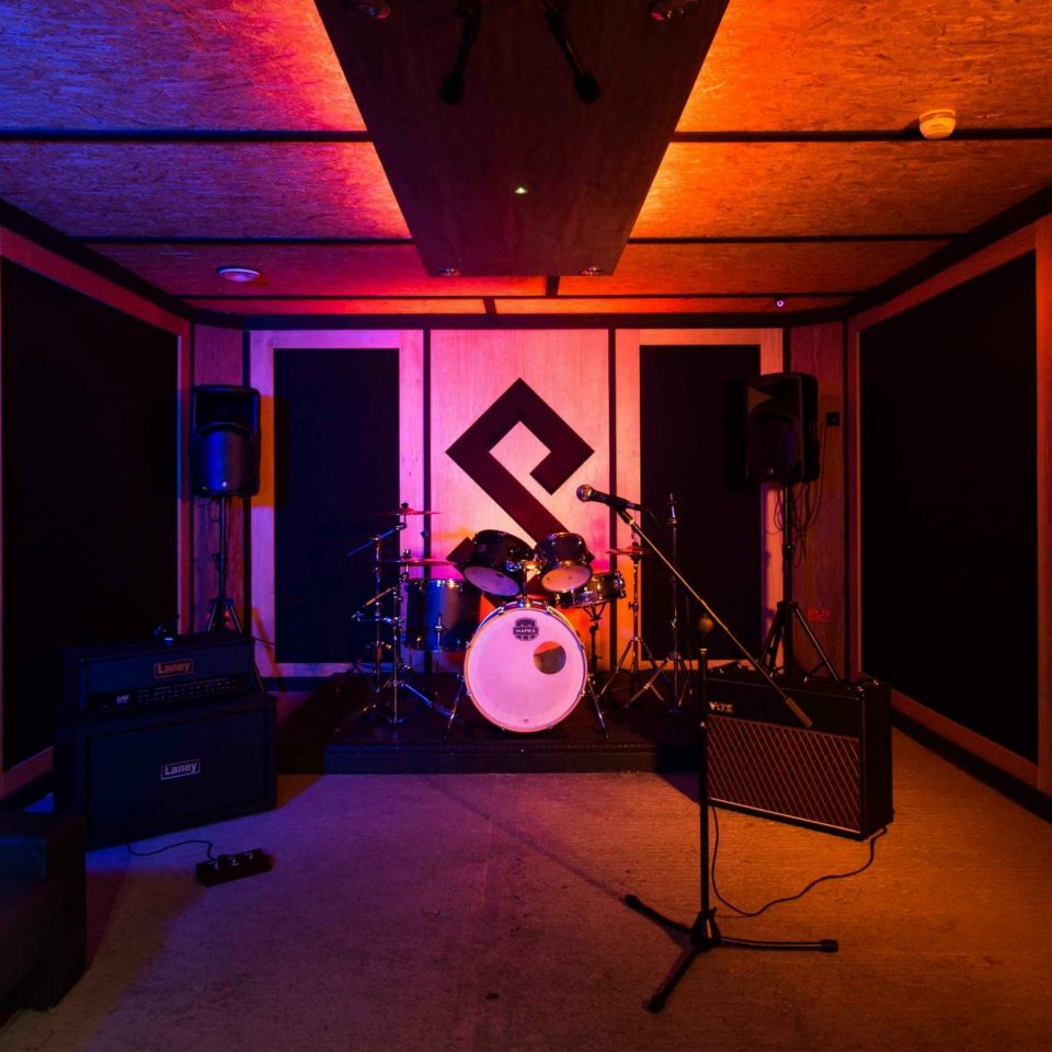 a photo showing a Pirate rehearsal room with amps and a drum kit