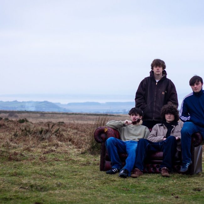 Four members of the band Subterrania with the backdrop of the wilderness